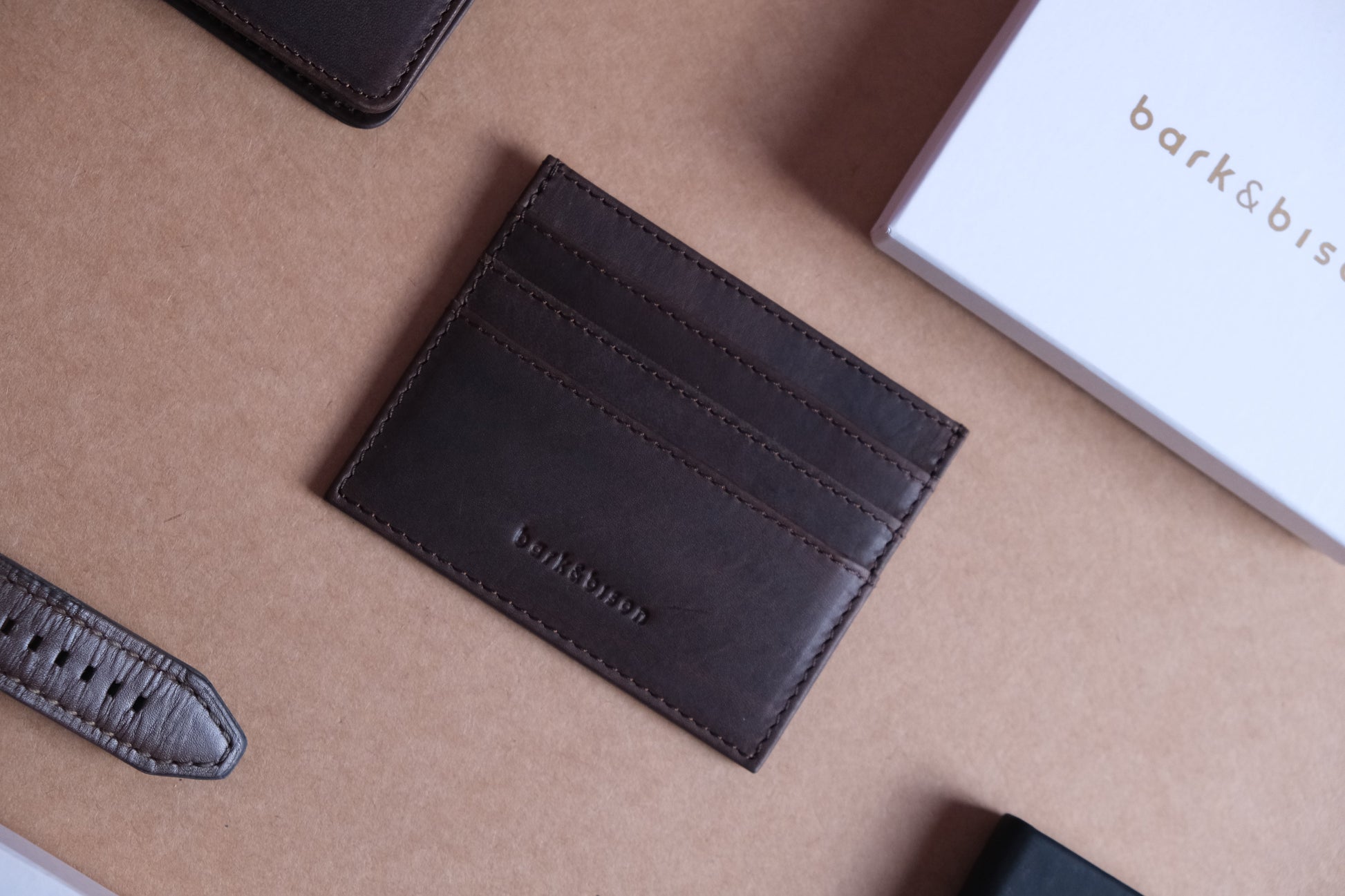 dark brown close to black cardholder and white box labelled with bark&bison