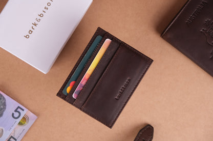 A leather brown card holder with multiple card slots embossed with bark&bison branding