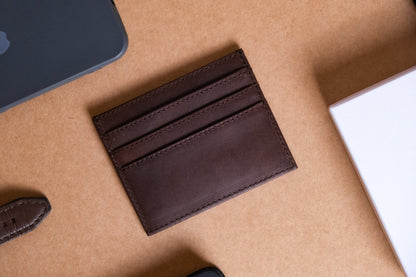 brown leather cardholder with multiple slots against light brown background