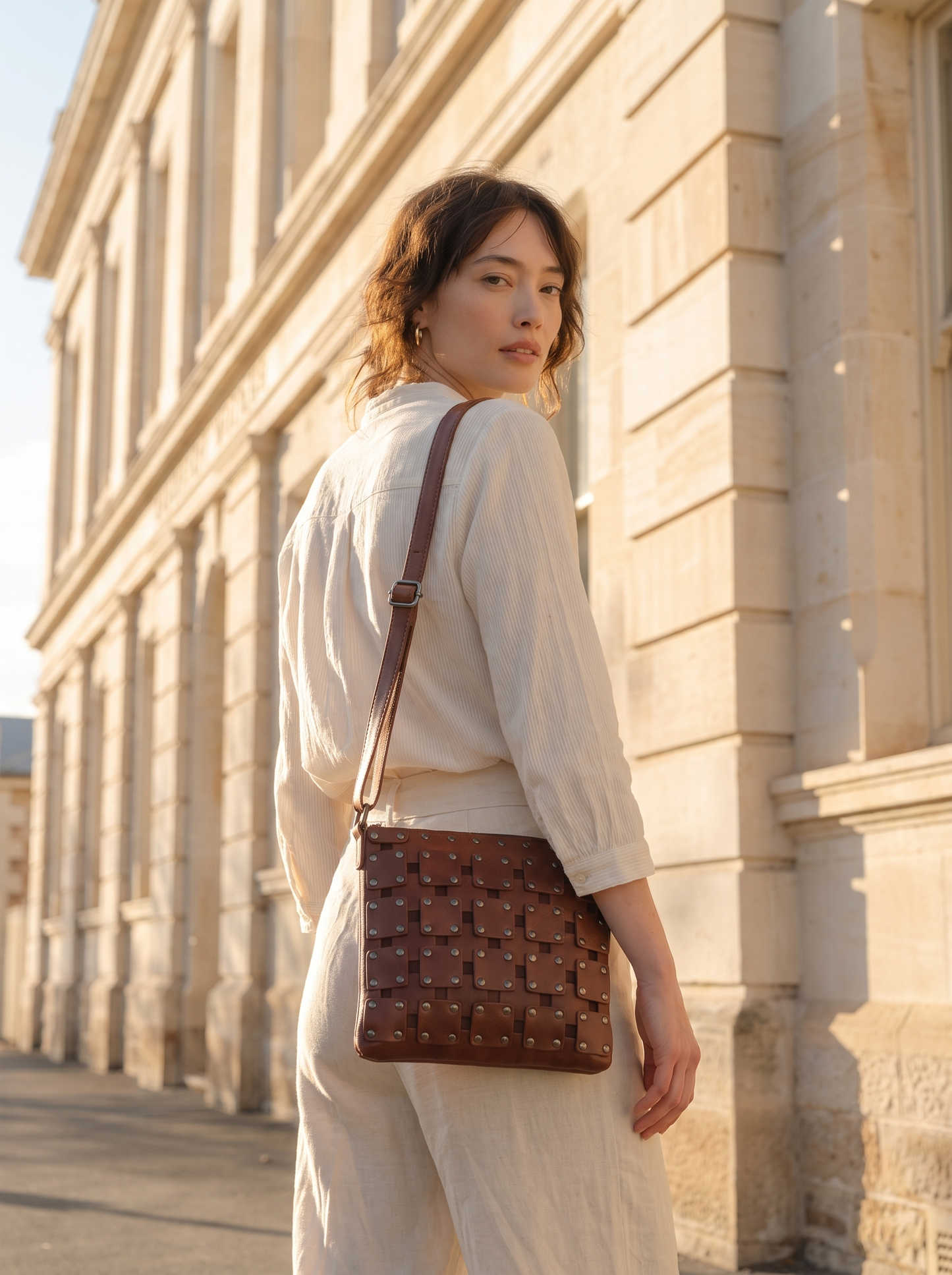 Gawler Sling bag worn crossbody, rear view against stone archway