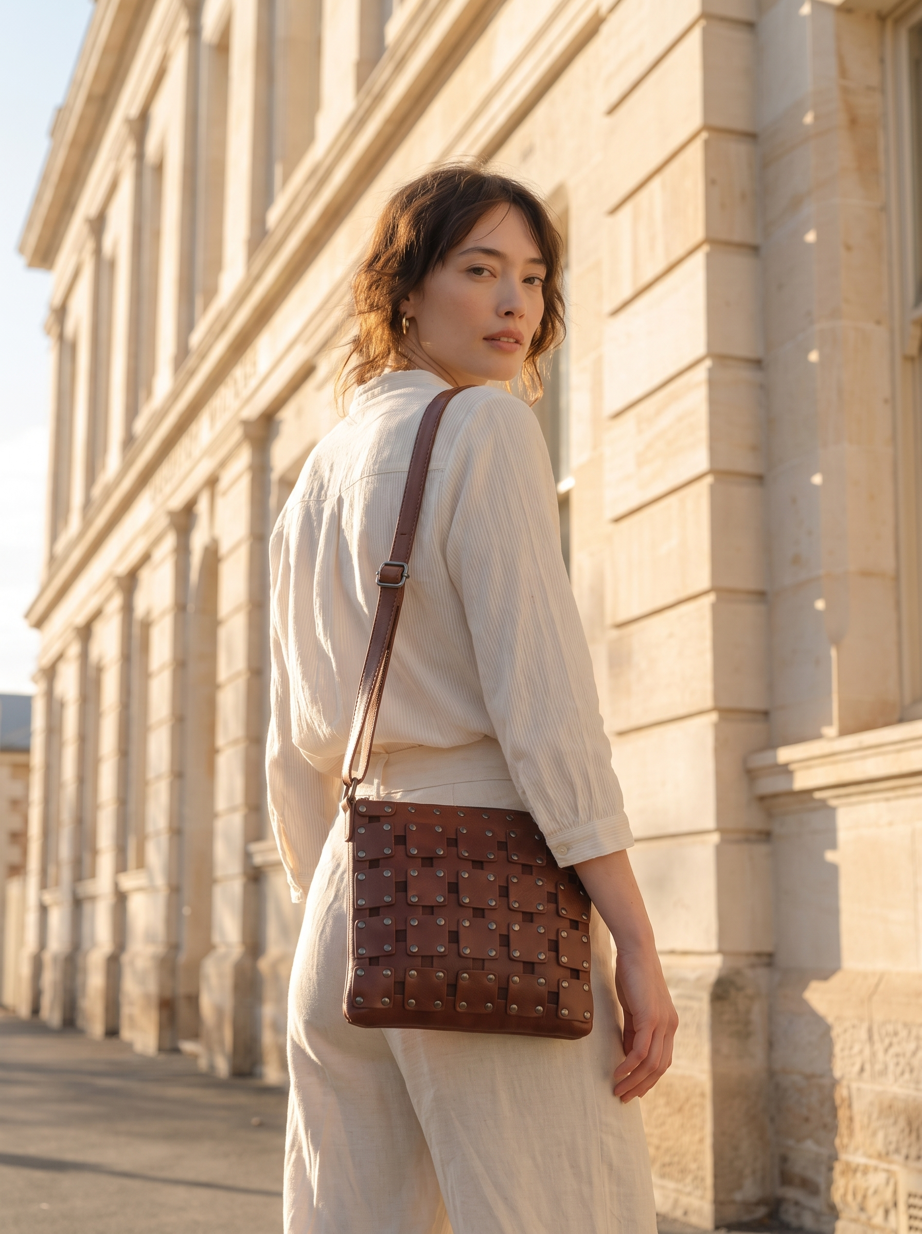 Gawler Sling bag worn crossbody, rear view against stone archway