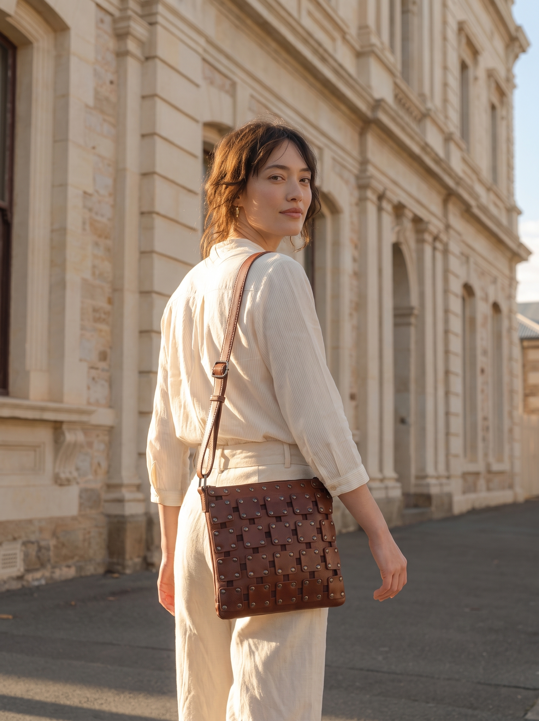 Gawler Sling crossbody bag worn over the shoulder, shown from behind beside a stone building facade