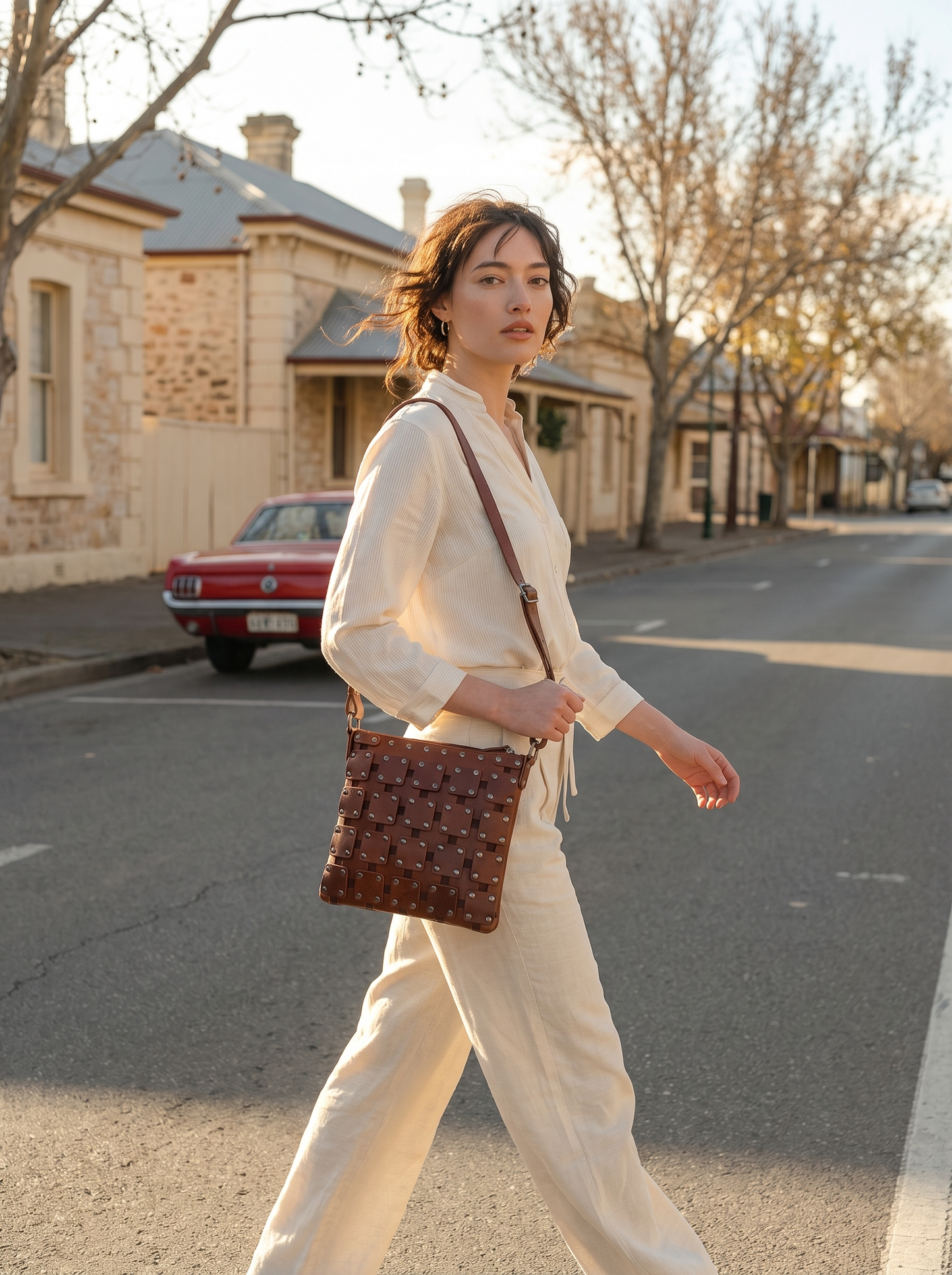 Model walking with the Gawler Sling crossbody bag on a heritage street