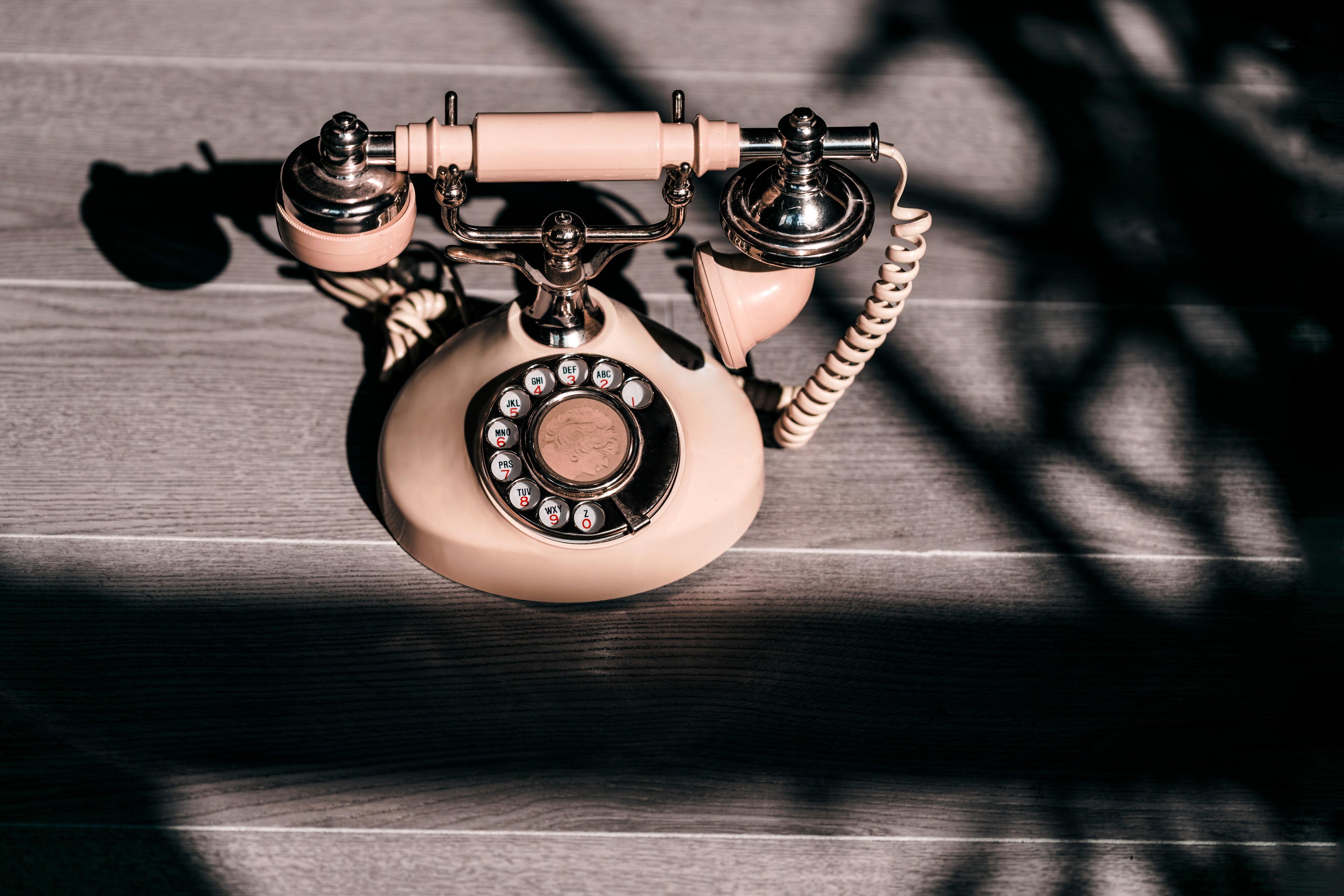 Old fashioned telephone placed on grey color matt.